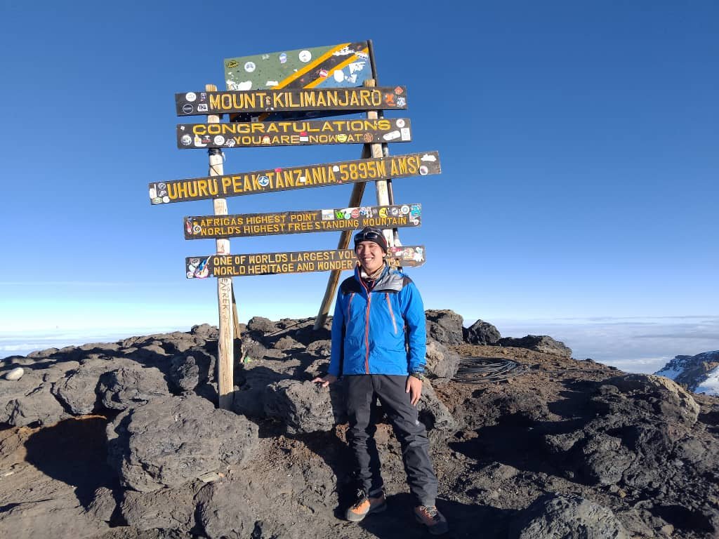 Trekker Standing At Uhuru Peak Summit Tanzania