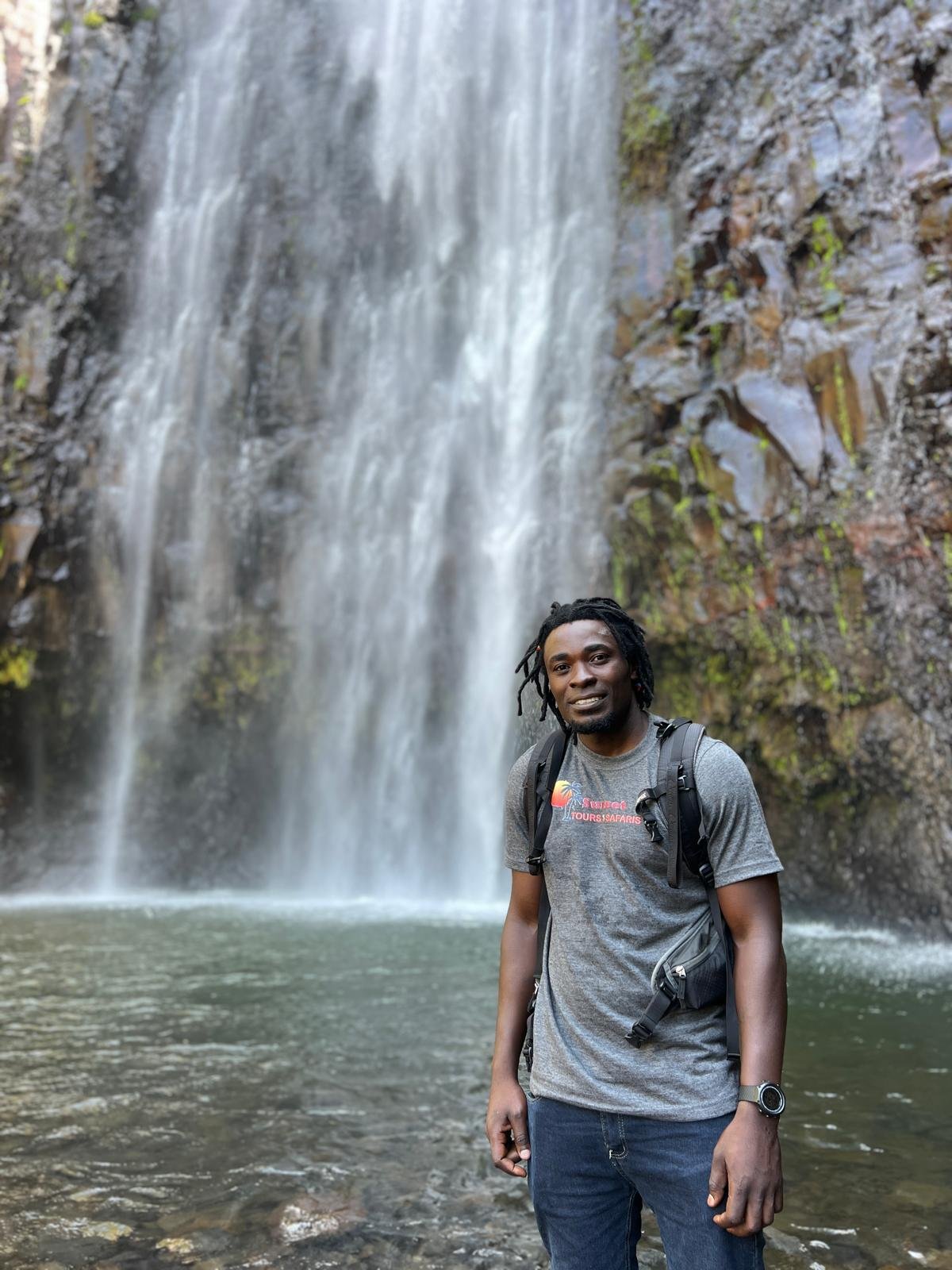 A visitor beside a Tanzania waterfall